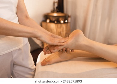 Foot massage with massage oil for woman while relaxing and resting at spa on vacation - Powered by Shutterstock