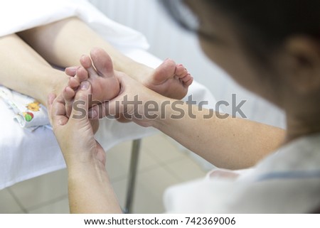 Foot massage in the patient. The doctor does the massage of the feet, heels and toes on the legs