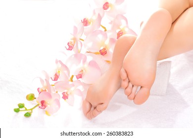 Foot massage in the spa salon with orchid