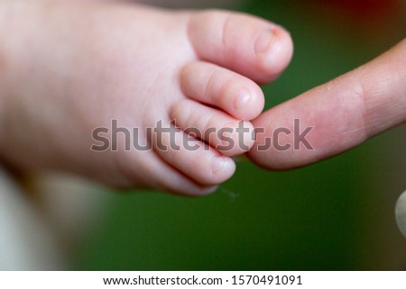 Foot of a month old baby. Close-up. Mom massages the leg of a monthly baby.