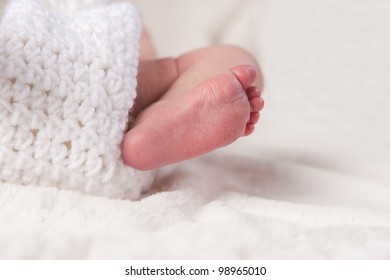 Foot Of A Newborn Baby In Crochet Blanket