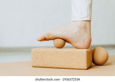 Foot on cork massage ball on cork block for plantar fascia massage and hydration. Concept: self care practices at home
