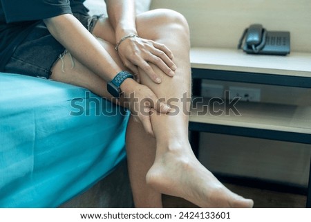 Foot pain, Asian woman sitting feeling foot pain at home, woman suffering from foot pain using hand massage to relax muscles from soles of feet

