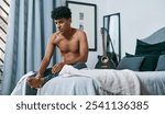 Foot pain, morning and wake up with teen on bed in home for joint massage, injury recovery or rehabilitation. Accident, medical or mistake and shirtless person in bedroom of apartment with arthritis