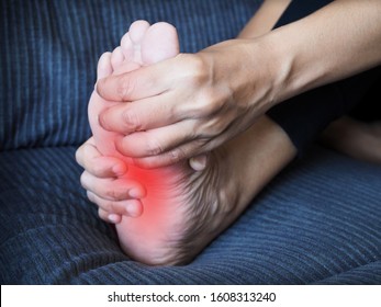 Foot Pain, Sore Feet Of Young Thai Asian Woman And Use Hand To Massage Feet And Soles To Relieve Pain.