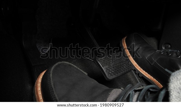 Foot pressing foot pedal of a car to drive.\
Accelerator and brake pedal in a car. Driver driving the car by\
pushing accelerator and break pedals of the car. inside vehicle.\
control pedal. Close up.