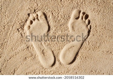 Foot prints in the sand. The concept of travel and vacation by the sea. Foot disease, orthopedic problems, flat feet, heel, toenails diseases