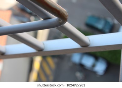 Foot In Sandals On The 10th Floor Balcony With Cars Underneath