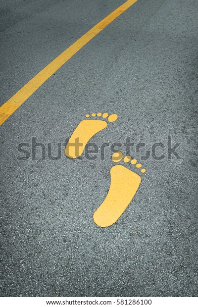 Foot sign on asphalt
road and yellow line