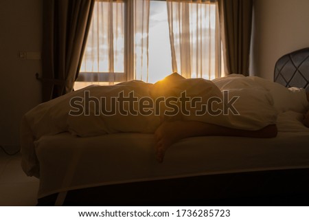 Foot sleeping in the morning at dawn, the girl hangs down the bed. Spy photo. Deep sleep