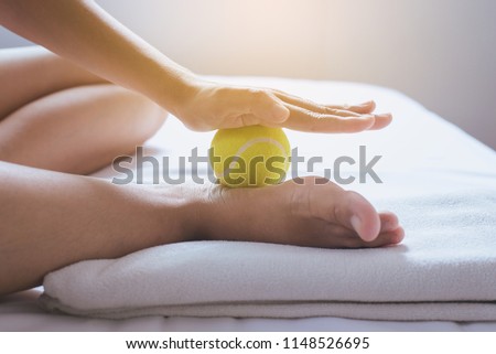 Foot soles massage for plantar fasciitis,Woman hands giving massage with tennis ball to her foots in bedroom