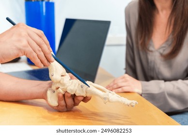 Foot Specialist Explaining Anatomy Using Model - Powered by Shutterstock