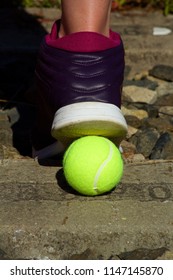 Foot In A Sports Shoe And A Tennis Ball.A Woman In A Tennis Shoe And  Standing On A Yellow Tennis Ball.Woman Standing On Overgrown Train Track.