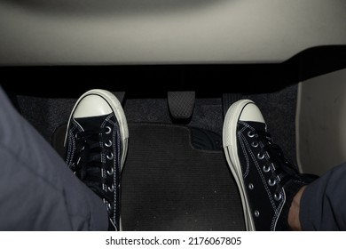 Foot Stepping On The Accelerator And Clutch Pedal In Manual Car.