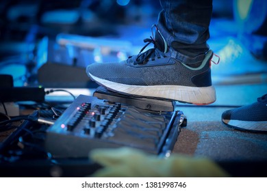 Foot Stepping on a Guitar Pedal Effect on a stage - Shutterstock ID 1381998746
