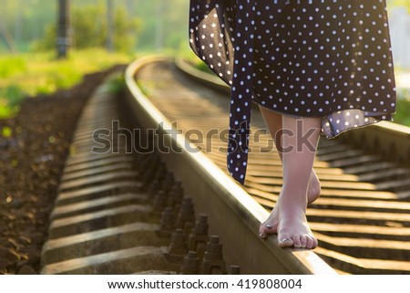 Foot woman walking on the railroad.