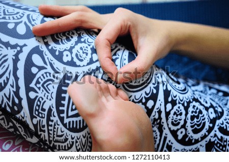 foot of a woman who lies in the lotus position and a hand, OM