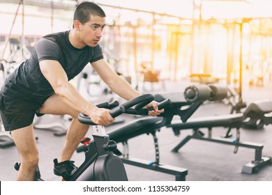 Footage Of A Man Working Out In Gym On The Exercise Bike, Young Man Cycling In The Gym. Man Exercising In Fitness Gym For Good Health.