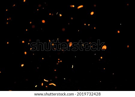 Footage of sparks flying from the fire. Isolated on a black background.