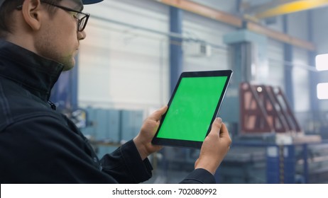 Footage of a tablet with green mock-up screen being used by a worker in industrial environment in a factory. - Powered by Shutterstock