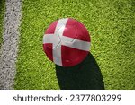 football ball with the national flag of denmark on the green field near the white line