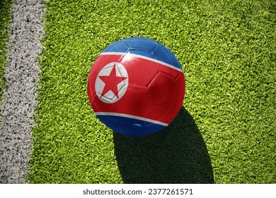 football ball with the national flag of north korea on the green field near the white line - Powered by Shutterstock