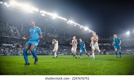 Football Championship: African Blue Team Forward Hits the Ball and Scores Perfect Goal. Goalkeeper Jumps and Fails to Catch, Protect Goals. Crowd of Fans Cheers Happily. Beautiful Cinematic Edit. - Powered by Shutterstock