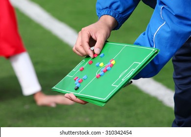 Football coach gives directions to players on desk - Powered by Shutterstock