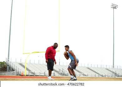 Football coach training and teaching a football player. - Powered by Shutterstock