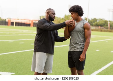 Football Coach Training A Young Athlete.