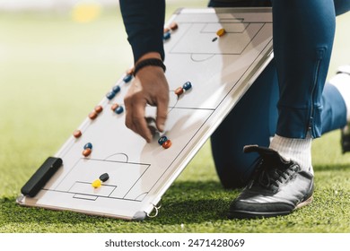 Football Coach Using Soccer Tactics Strategy Board. Coach explaining the game plan to school soccer players - Powered by Shutterstock