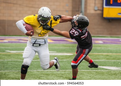 Football Cornerback Fighting Through A Stiff Arm From Wide Receiver.