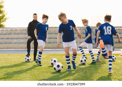 Football Education for Kids. Physical Education for Children. Young Coach With Kids in Soccer Team on Training Unit. Youth Team Coach Training School Boys in Football Soccer