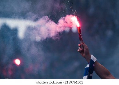 Football fan burns flare in the hand with scarf at the stadium - Shutterstock ID 2159761301