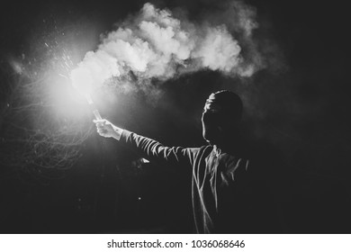 A Football Fan With A Smoke Bomb In His Hands. Ultras Fan With Pyrotechnics In Hand.  A Football Fan In The Smoke From A Smoke Bomb.