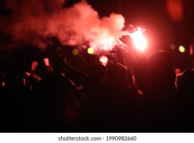 Football fans cheer with lighted torches during the match - Shutterstock ID 1990982660