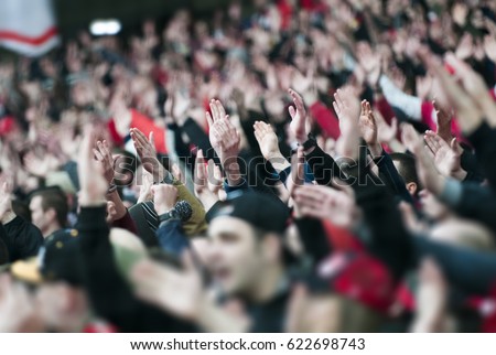 Football fans clapping on the podium of the stadium
