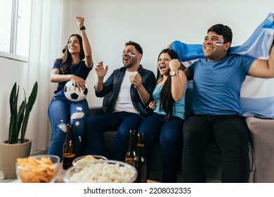 Football fans friends watching Argentina national team in live soccer match on TV at home - Powered by Shutterstock