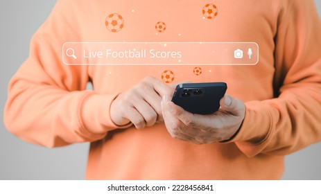 Football fan's holding smartphone for search live football scores. Searching Browsing Internet Data Information with search bar. Search Engine technology networking Concept.
