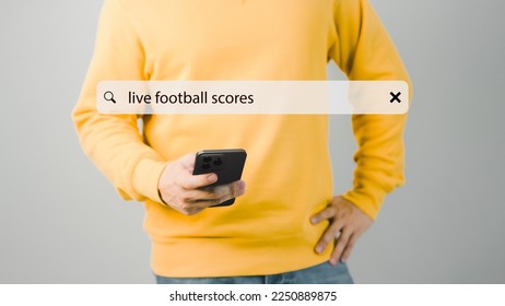 Football fan's holding smartphone for search live football scores. Searching Browsing Internet Data Information with search bar. Search Engine technology networking Concept.
