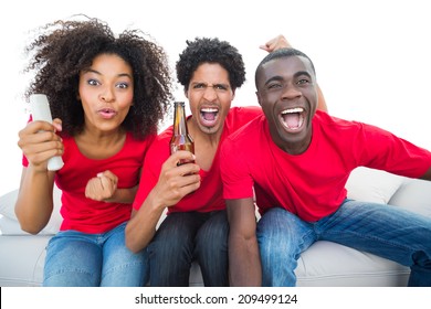 Football Fans In Red Cheering On The Sofa With Beers On White Background