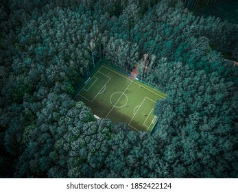 Football field lost among green summer trees in a Moscow park. Russia.