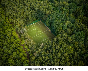 Football field lost among green summer trees in a Moscow park. Russia.