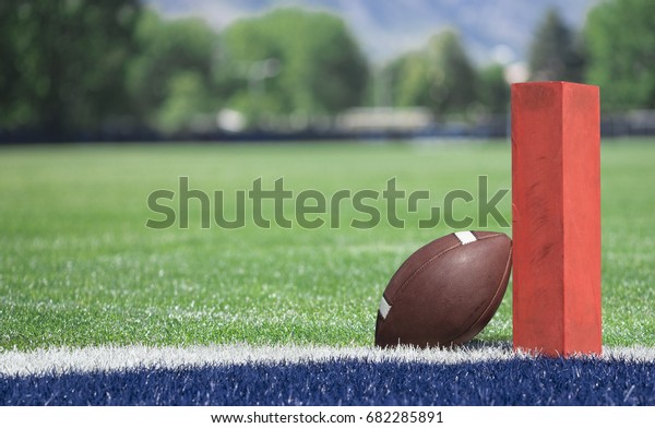 Football field low end zone view. Selective focus\
photo of the pylon and touchdown line on a football field. Low\
angle view from the end\
zone