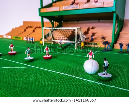 Football figures in action in front of the goal on a grass field