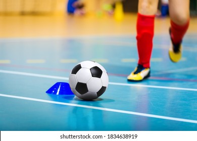Football Futsal Ball, Wooden Floor, Training Marker And Running Player In Cleats. Indoor Soccer Sports Hall. Sport Futsal Background. Indoor Soccer Winter League