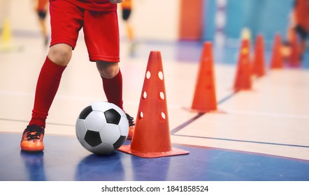 Football Futsal Training For Children. Soccer Training Dribbling Cone Drill. Indoor Soccer Young Player With A Soccer Ball In A Sports Hall. Player In Blue Uniform. Sport Background