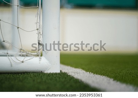 A football goal post structure which is placed on artificial turf ground pitch. Sport equipment object photo.
