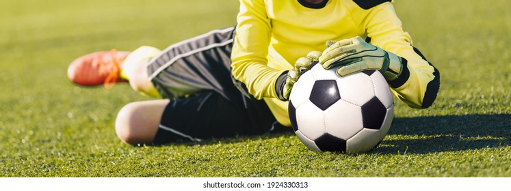 Football Goalkeeper Catching Ball. Young Boy Jumping Towards Soccer Ball and Saving Goal. Training Camp Drill for Young Goalkeepers - Powered by Shutterstock