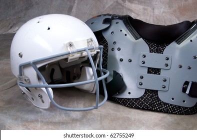 Football Helmet And Shoulder Pads On Tan Background